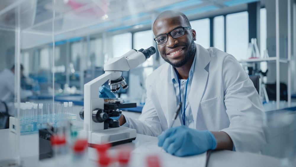 Smiling scientist and microscope